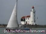 Segelyacht im Marker Meer/Niederlande vor dem Leuchtturm von Marken (Paard van  Marken)