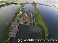 Luchtfoto/Luftbild: Stevinsluis in Den Oever von boven/von oben. Die Schleuse Den Oever am Abschlussdeich zwischen Wattenmeer und IJsselmeer aus der Vogelperspektive.
